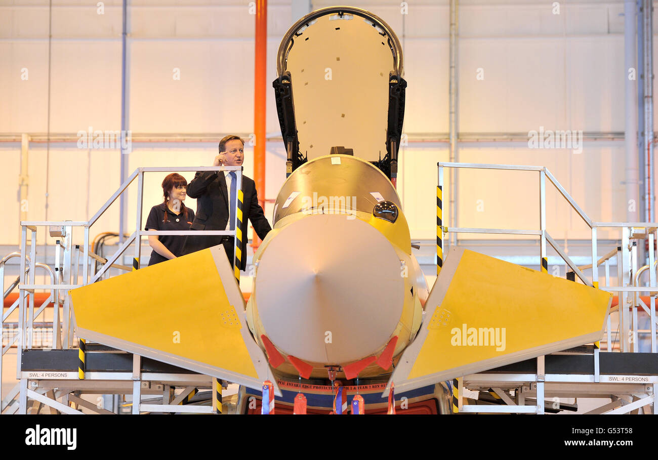 Prime Minister David Cameron views the Eurofighter Typhoon with apprentice Lauren Nuttall (left) during a visit to BAE Systems in Warton, Lancashire. Stock Photo