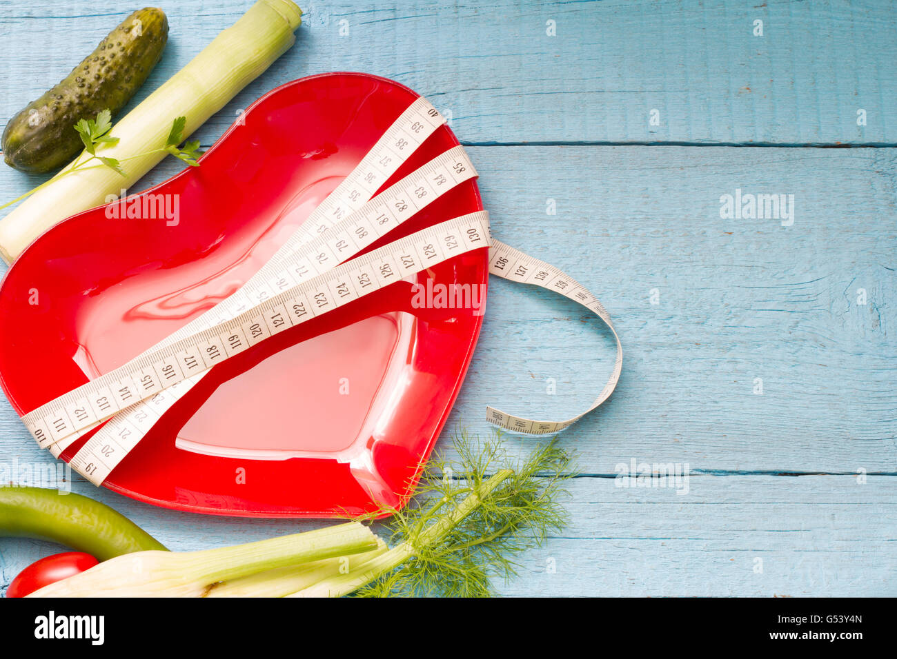 Fit and health abstract concept with red heart plate on wooden blue background Stock Photo