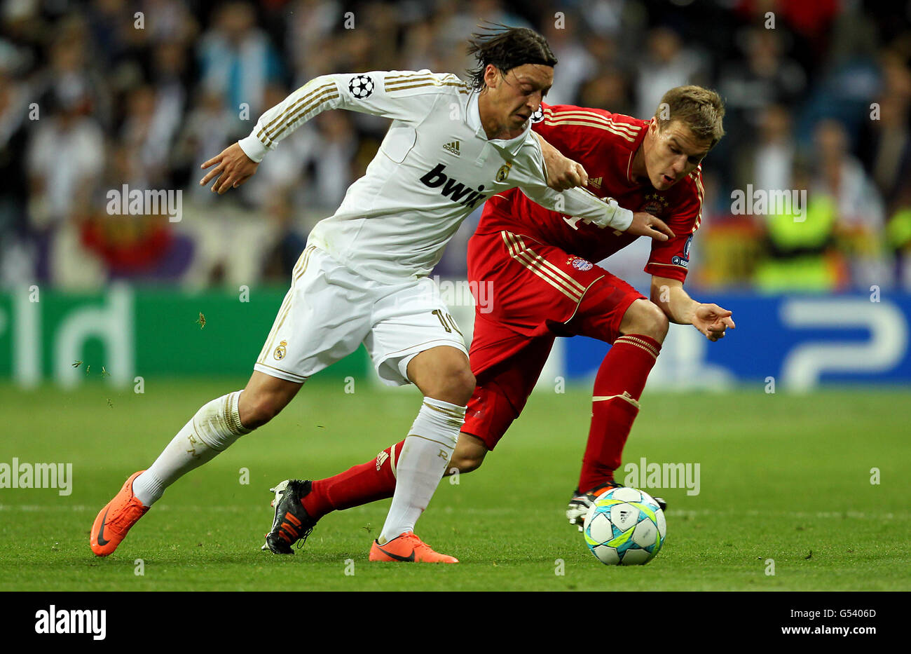 Real Madrid's Mesut Ozil and Bayern Munich's Holger Badstuber battle for the ball Stock Photo