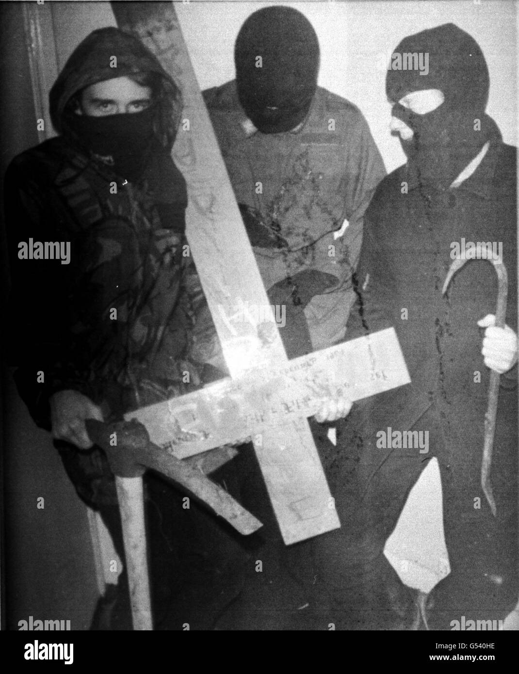 A picture believed to have been taken by the Hunt Retribution Squad, showing three masked anti-hunt campaigners with the cross taken from the grave of the 10th Duke of Beaufort, in Badminton Parish Church, Avon. * 08/09/00: The Countryside Alliance condemned threats to members of a hunt by the militant saboteur group the Hunt Retribution Squad, after members of the Old Surrey, Burstow and West Kent Hunt received letters warning they are considered as 'legitimate targets'. Stock Photo