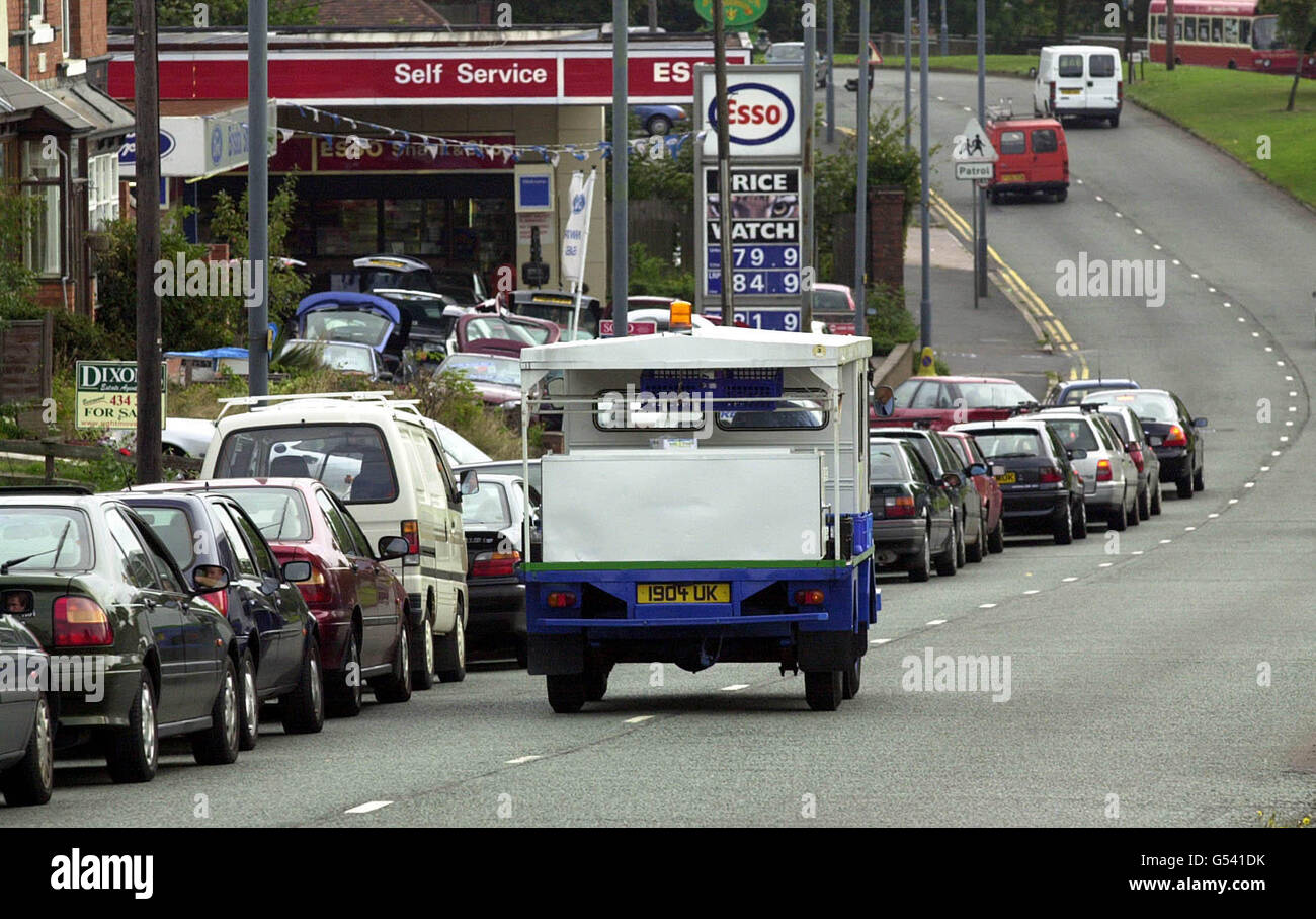 A milk float passes a queue of cars hoping to refuel at a petrol service station on Birmingham's Hagley Road. Stock Photo