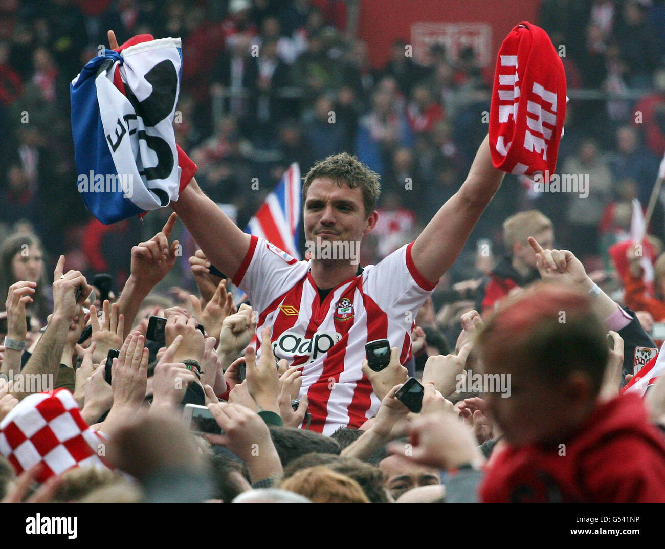 Southampton's Jos Hooiveld is carried off the pitch by jubilant fans at the end of the game following the clubs promotion to the Premier League during the npower Football League Championship match at St Mary's, Southampton. Stock Photo