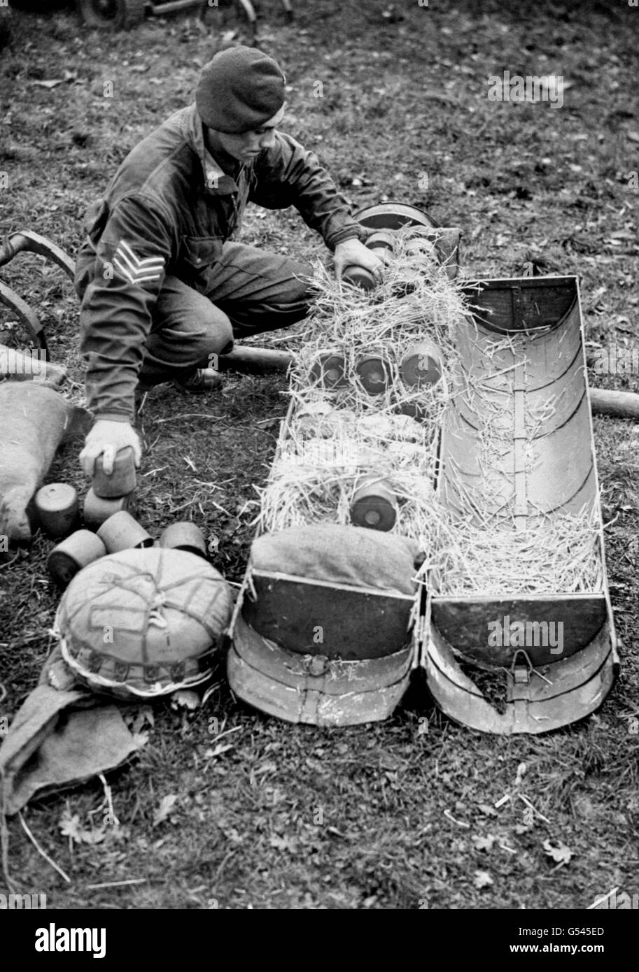 A Sergeant of the Royal Army Service Corps packs a canister which is to be dropped from an aeroplane. These men are essential to every movement the Army makes, delivering food, medical supplies, fuel, ammunition or weaponry. They are specially trained to pack panniers, fly in and drop the load by parachute. Stock Photo
