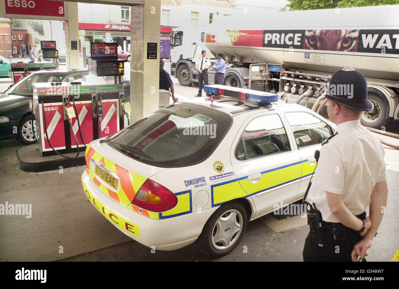 A policeman monitors a delivery of fuel to an Esso garage in Gloucester Road in Horfield, Bristol. The tanker had earlier left Avonmouth Docks. Stock Photo