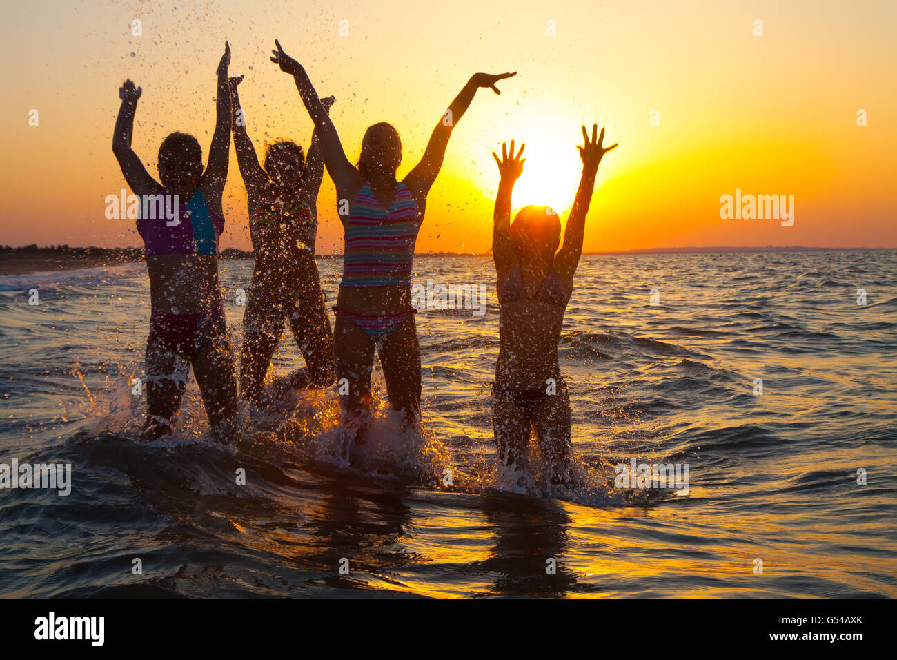 Group of happy young girls jumping at the beach Stock Photo - Alamy