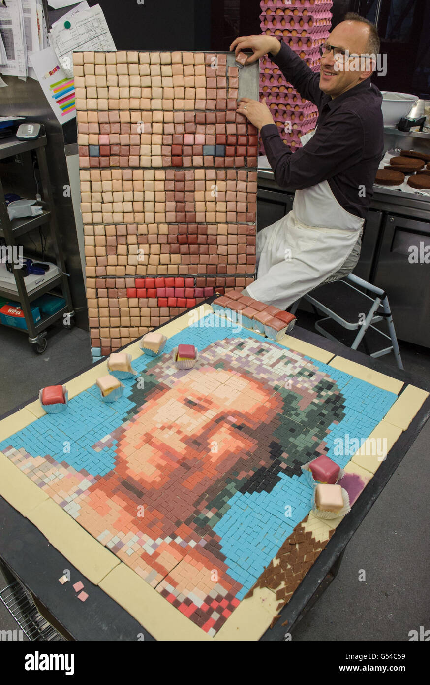 Chef Gerhard Jenne works on a test section of a pixellated portrait of Queen Elizabeth II, made out of cakes, at Konditor and Cook, in the City of London. Stock Photo
