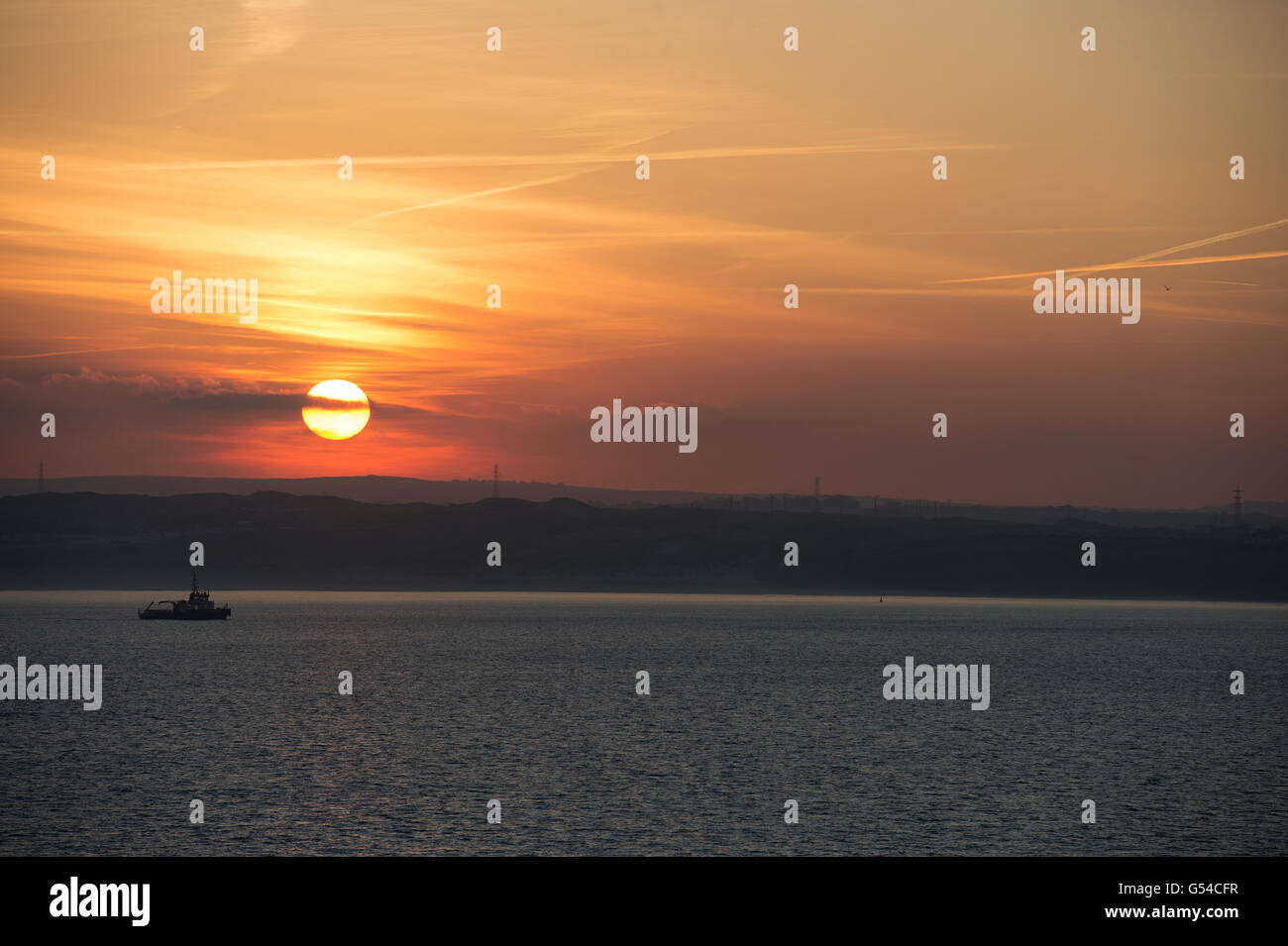 Sunrise with fishing boat anchored in the bay Stock Photo - Alamy
