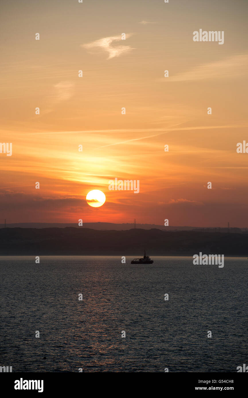 Sunrise with fishing boat anchored in the bay Stock Photo - Alamy