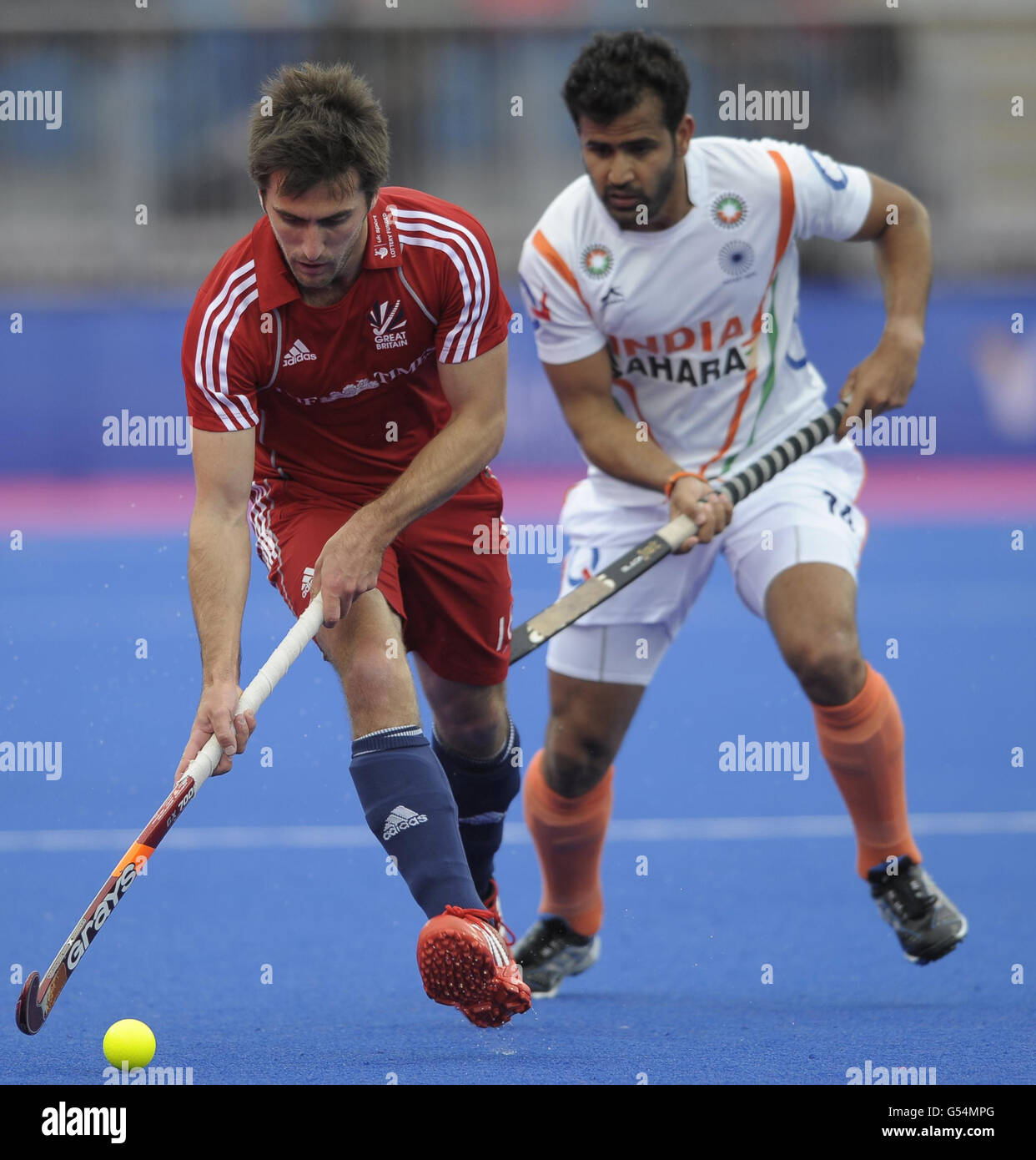 Great Britain's Adam Dixon gets away from India's Tushar Khandker during the Visa International Invitational Hockey Tournament at the Riverbank Arena, London. Stock Photo