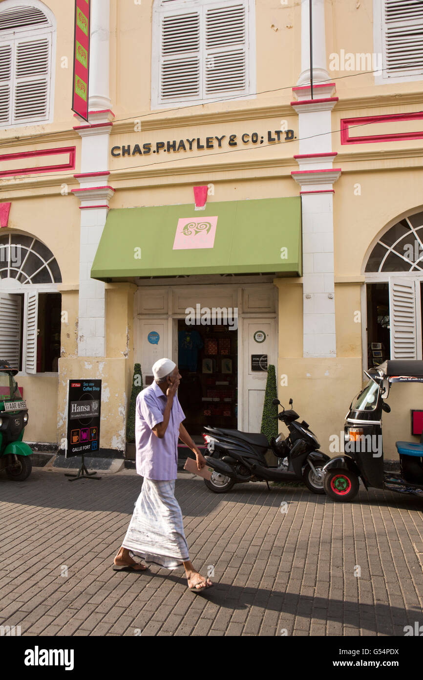 Sri Lanka, Galle Fort, Pedlar Street, Moslem man in lunghi walking past Chas P Hayley's original shop Stock Photo