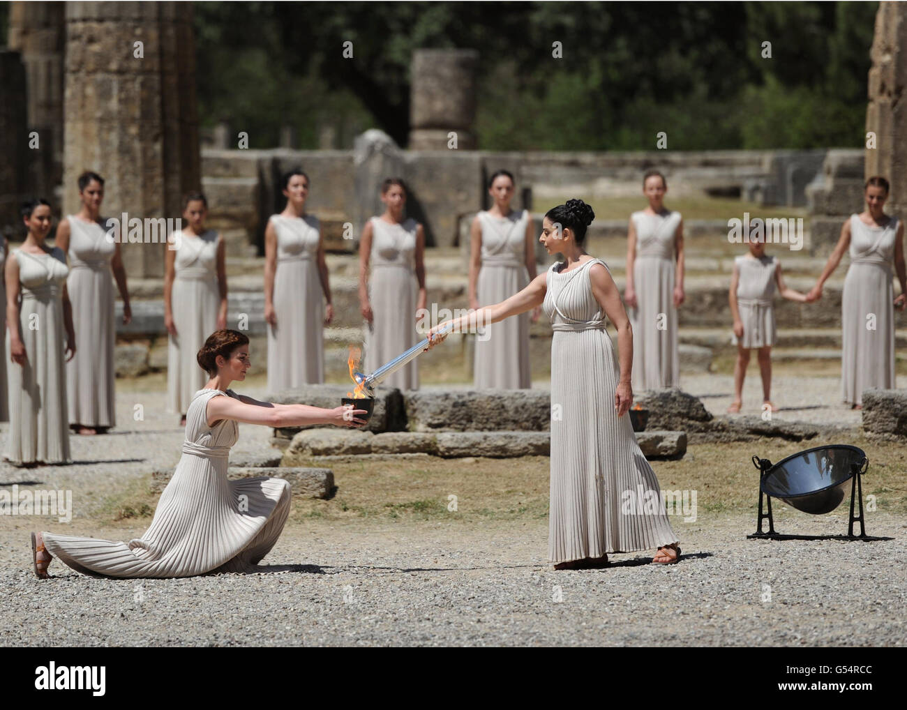 OLYMPIA, Greece - An actress receives the Olympic flame lit during a ...