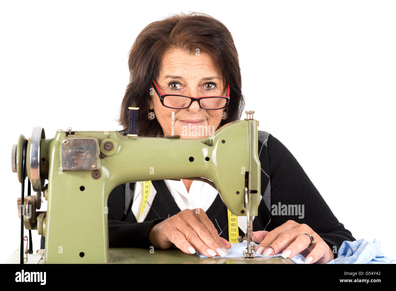 Beautiful senior woman with sewing machine isolated in white Stock Photo Alamy