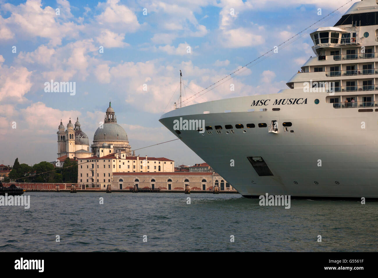 A huge cruise liner in the Bacino di San Marco dwarfs the Dorsoduro waterfront and the Santa Maria della Salute, Venice, Italy Stock Photo