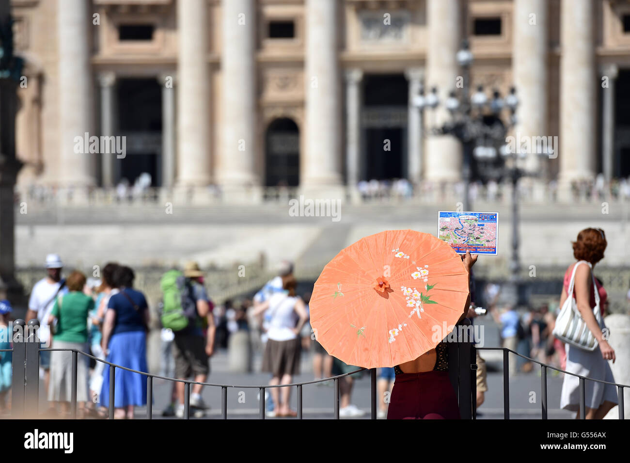 Japanese tourist guide with orange umbrella and guide book outside Saint Peters Vatican City Rome Stock Photo