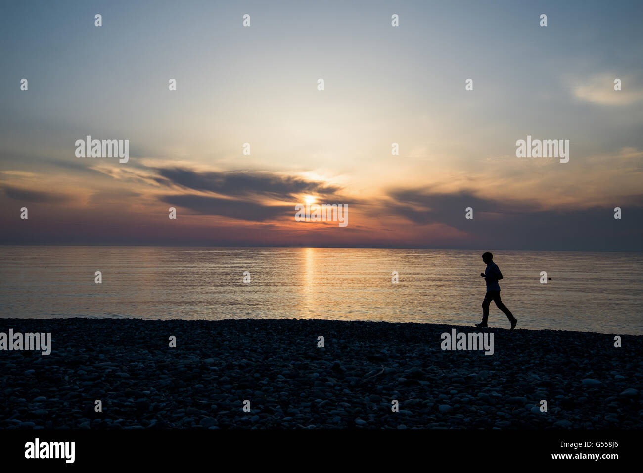 silhouette of man running on the beach at sunset Stock Photo - Alamy