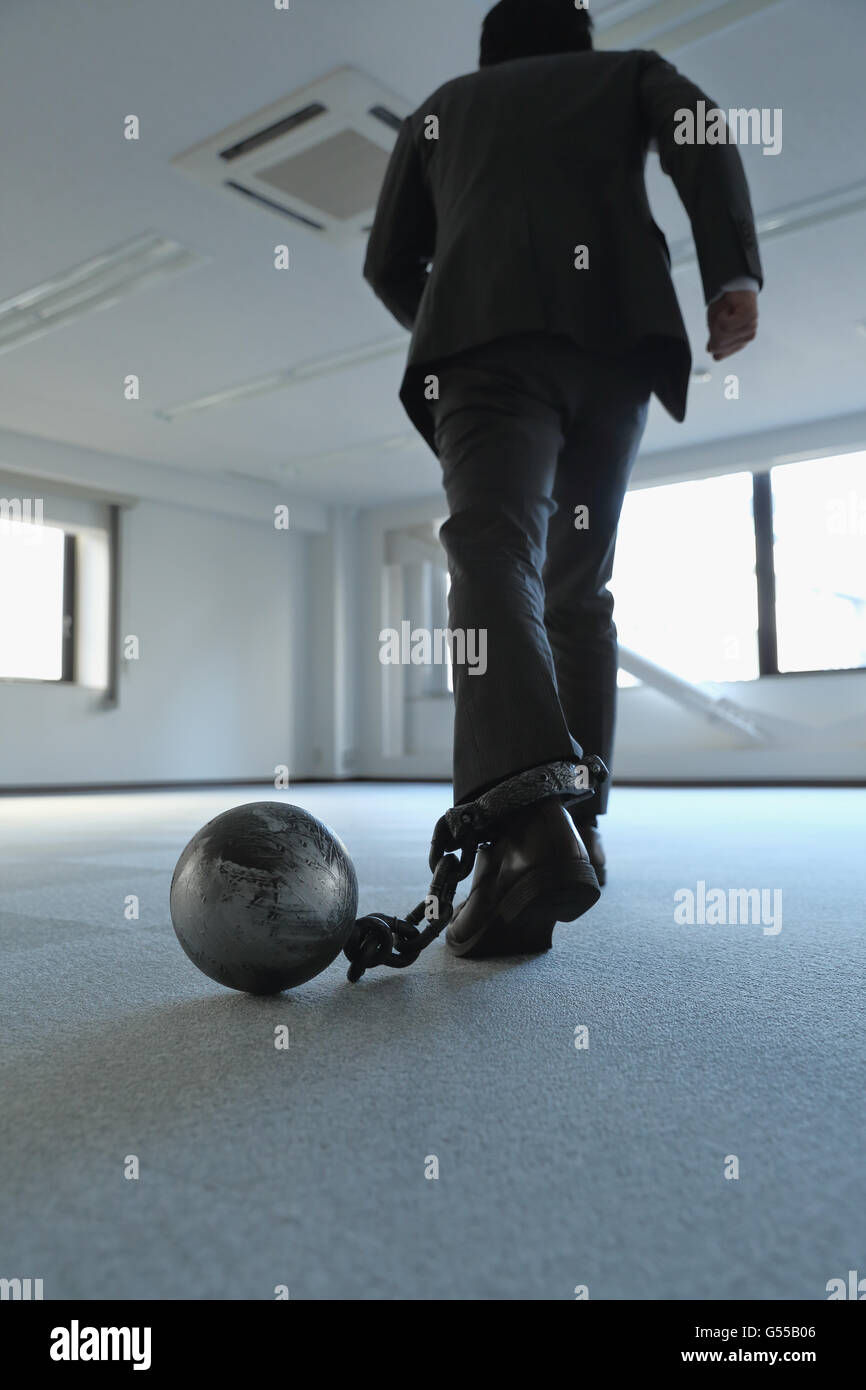 Japanese businessman with ball and chain Stock Photo