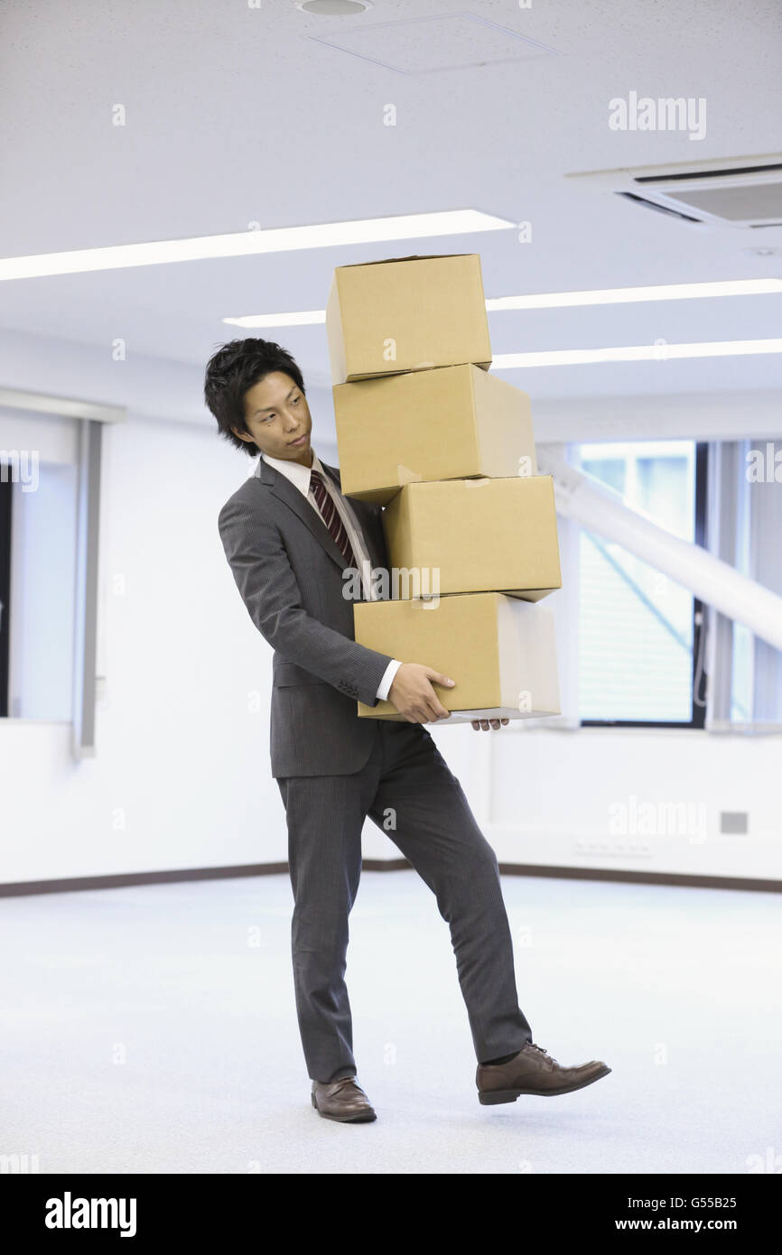 Young Japanese businessman carrying boxes Stock Photo