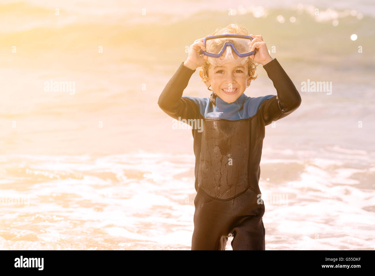 cute little kid smiling with snorkel in the waves Stock Photo