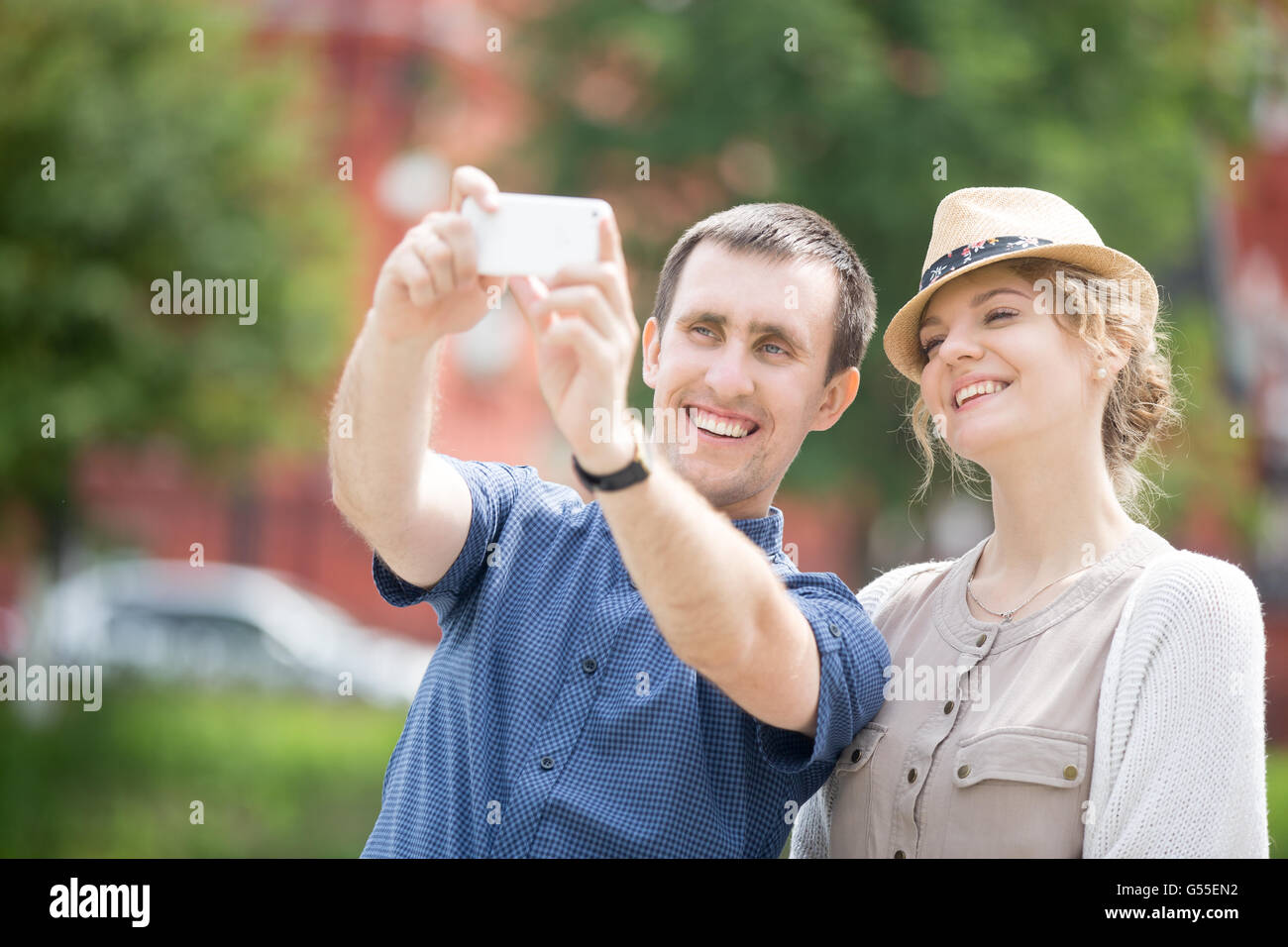Portrait of happy beautiful travelers couple making selfie during abroad trip with smartphone. Attractive young traveling girl Stock Photo