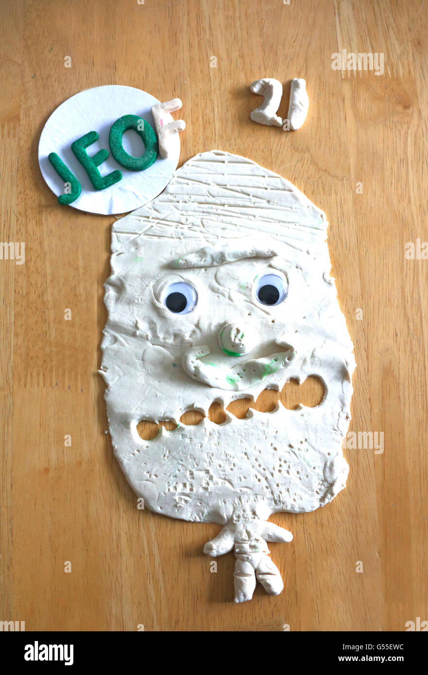 A funny face modelled in play dough on a flat surface. Stock Photo