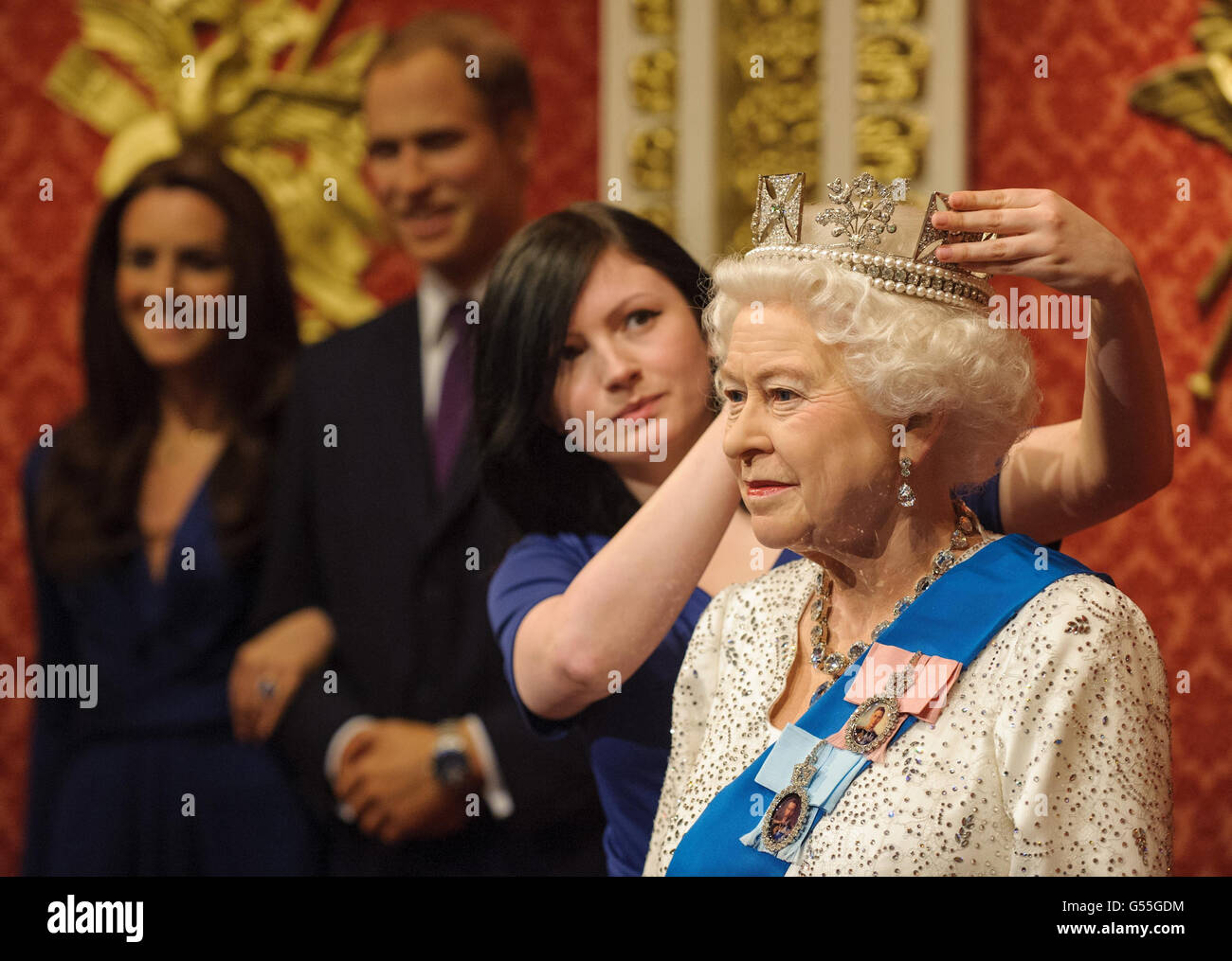 Madame Tussauds employee Lisa Burton puts the finishing touches to the new waxwork figure of Queen Elizabeth II, made to coincide with her Diamond Jubilee, during its unveiling at Madame Tussauds, in central London. Stock Photo