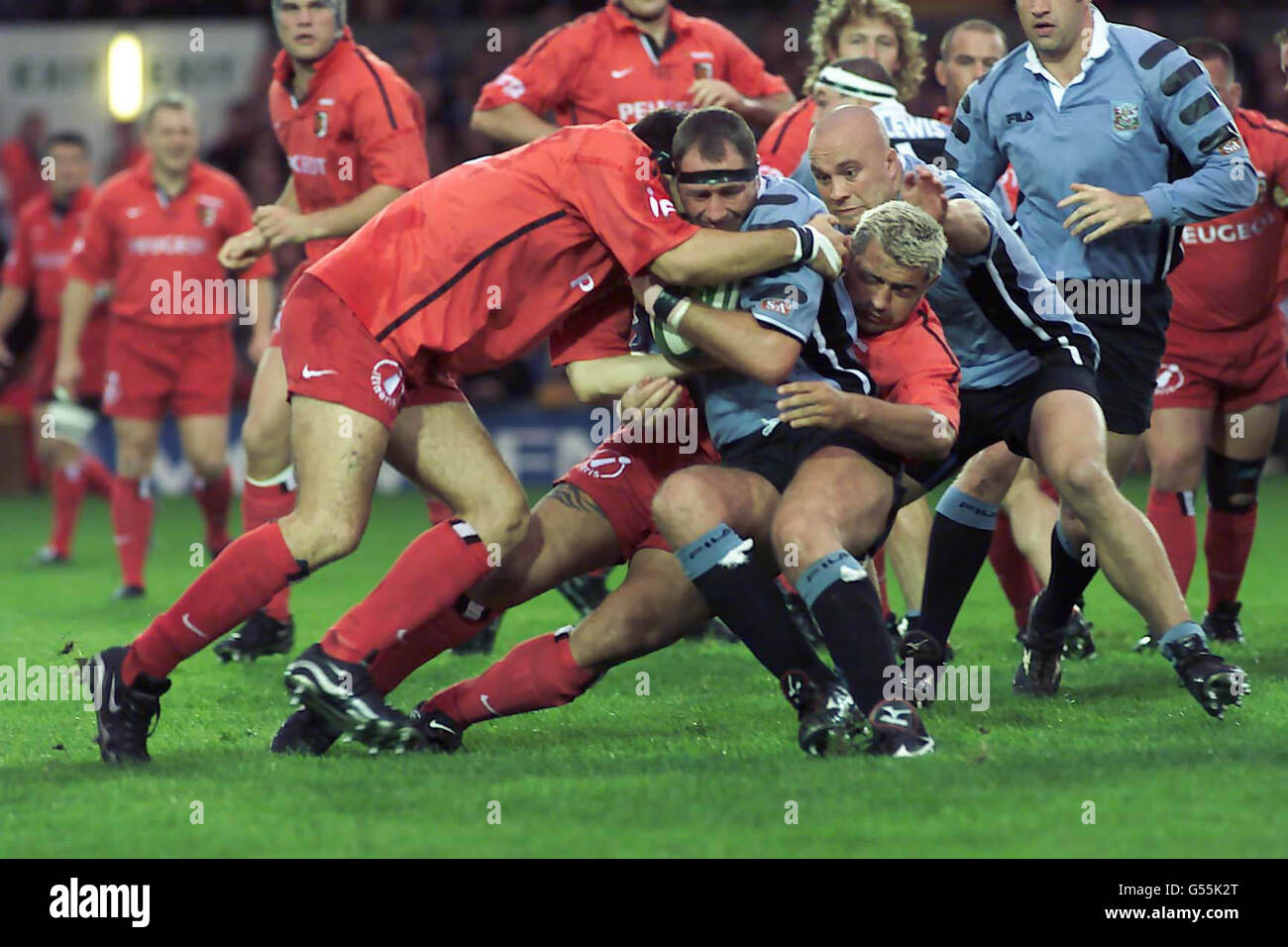 Emyr Lewis for Cardiff RFC (blue and black with head band) runs into the Toulouse defence during