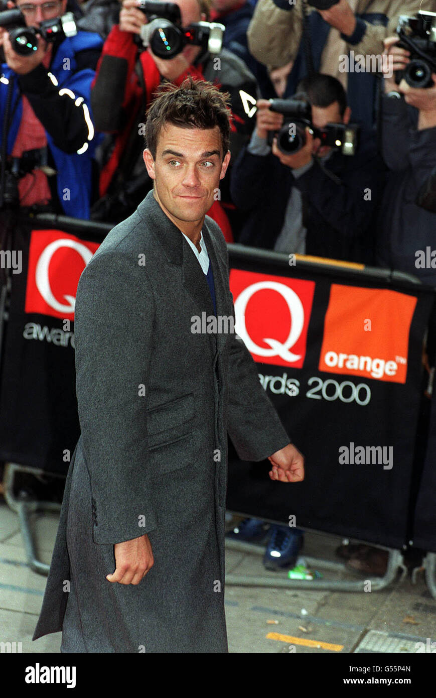 Singer Robbie Williams arrives at the Park Lane Hotel, central London, for the Q Awards. The event, sponsored by music magazine Q, is one of the highlights of the music industry's year. * 1/12/2000: Pop idol Robbie Williams will shatter a wall of silence surrounding Aids by symbolically using a 50-tonne crane to smash through a wall. The Rock DJ singer will be in the driving seat to direct a wrecking ball through the barrier at a building site in London for children's charity Unicef. Stock Photo