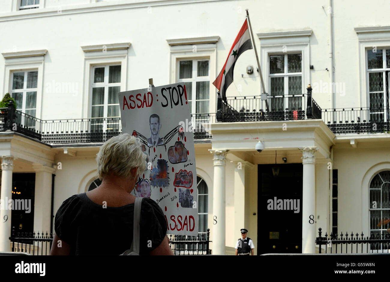 A protester holds a sign outside the Embassy of the Syrian Arab Republic in central London as Syria's Charge D'Affaires is being expelled from Britain along with two other diplomats. Stock Photo
