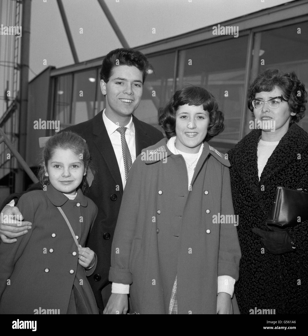 Pop singer Cliff Richard with his sisters Joan, 10, left, and Jacqueline, 13, and mother, Dorothy Webb, at Heathrow Airport, before boarding a plane bound for Spain where they are spending the Christmas holiday. Stock Photo