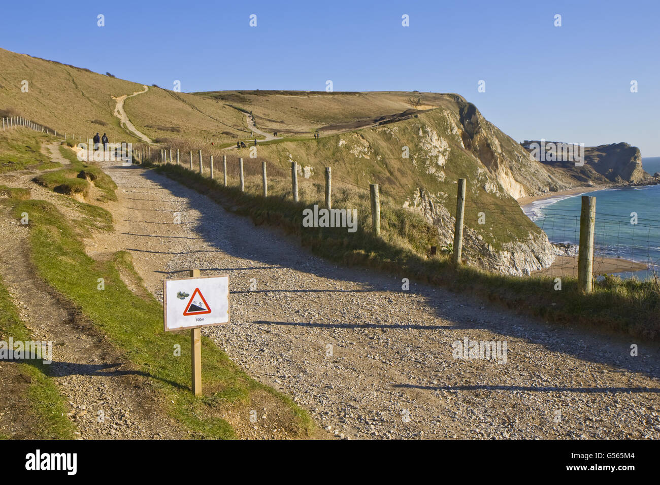View of coastal footpath and sign warning of 45 degree gradient for walkers, near Durdle Door, Dorset, England, January Stock Photo