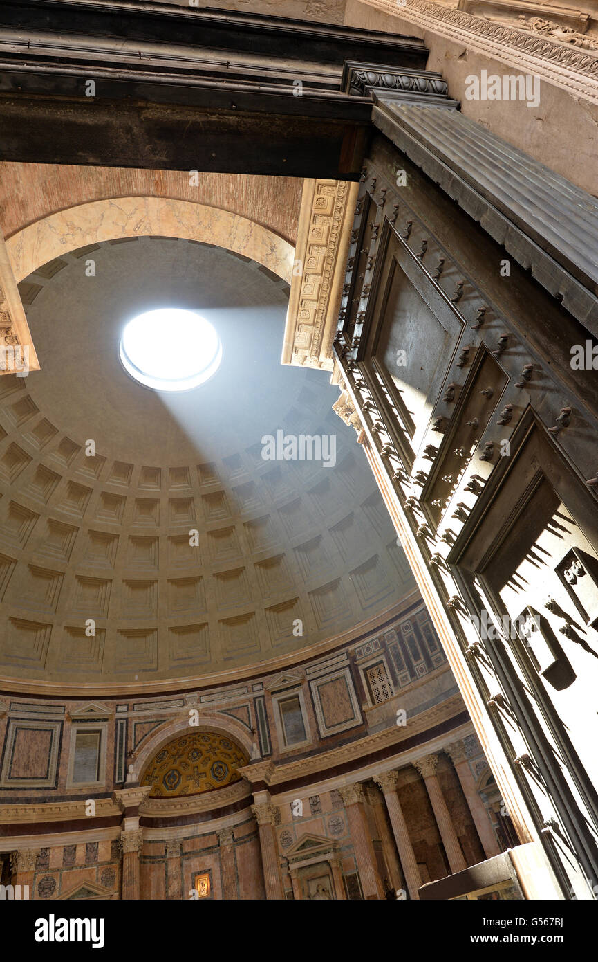 Rays of sunlight from the iconic ceiling racking across the door studs of the Pantheon Rome Stock Photo