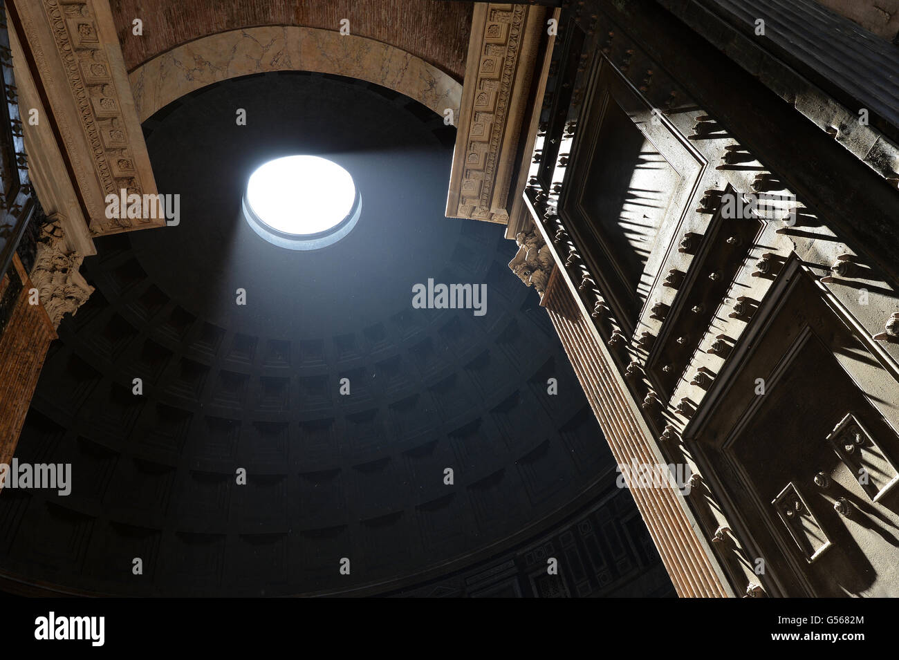 Pantheon Rome with strong shafts of sunlight illuminating the stud door Stock Photo