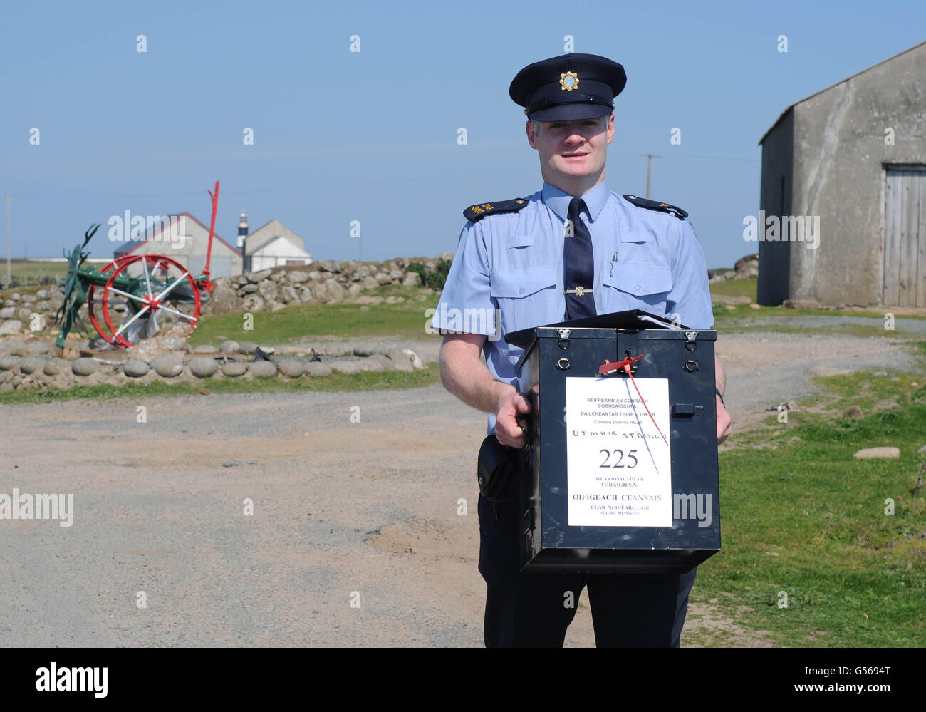 Garda Eugene Organ carrying a ballot box to the polling station for voting on the fiscal treaty referendum on Tory Island off the coast of Donegal, Ireland. Stock Photo