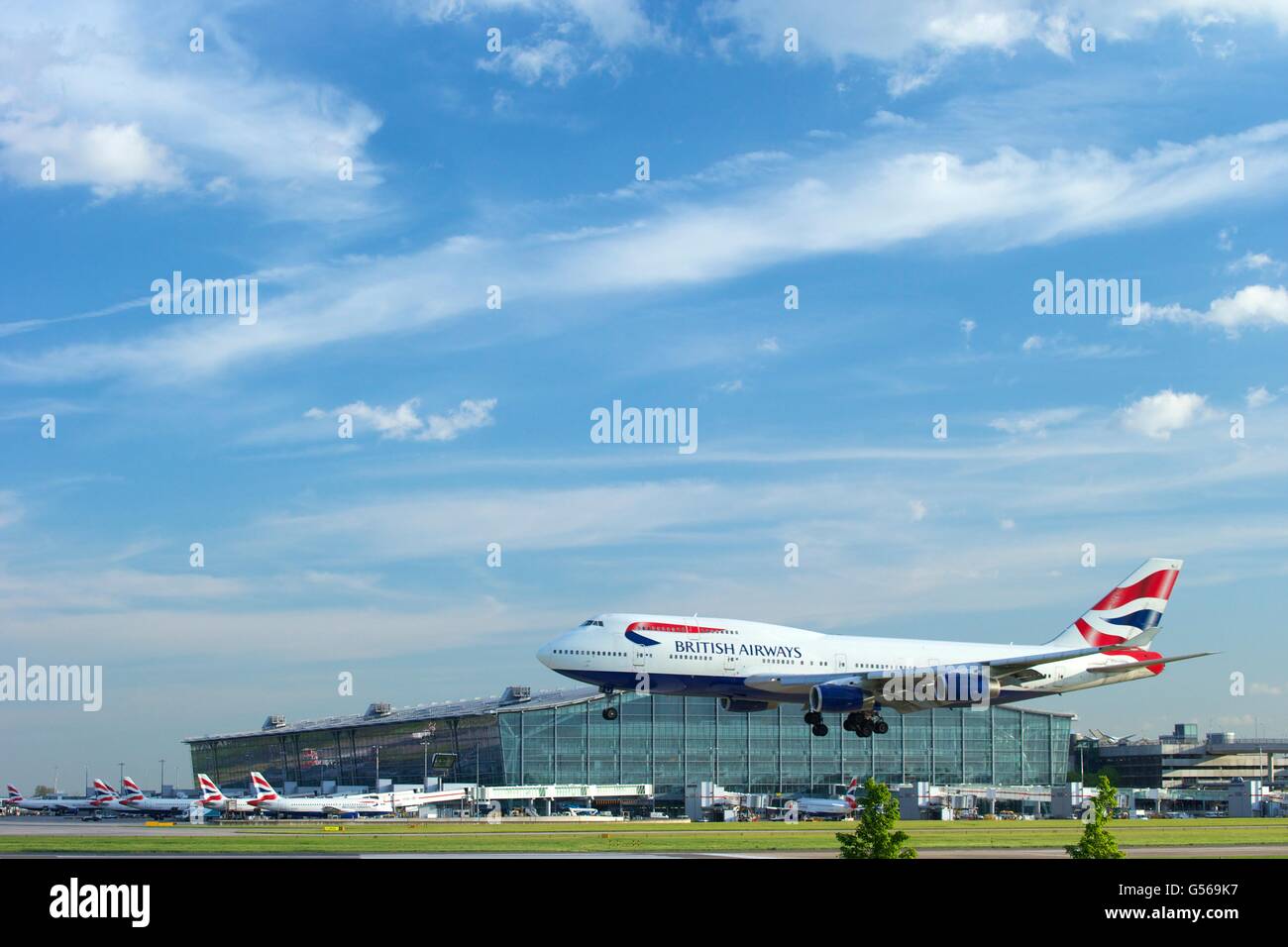 British AIrways flight landing at Heathrow Airport with Terminal 5 behind, London, England, UK, GB, Stock Photo