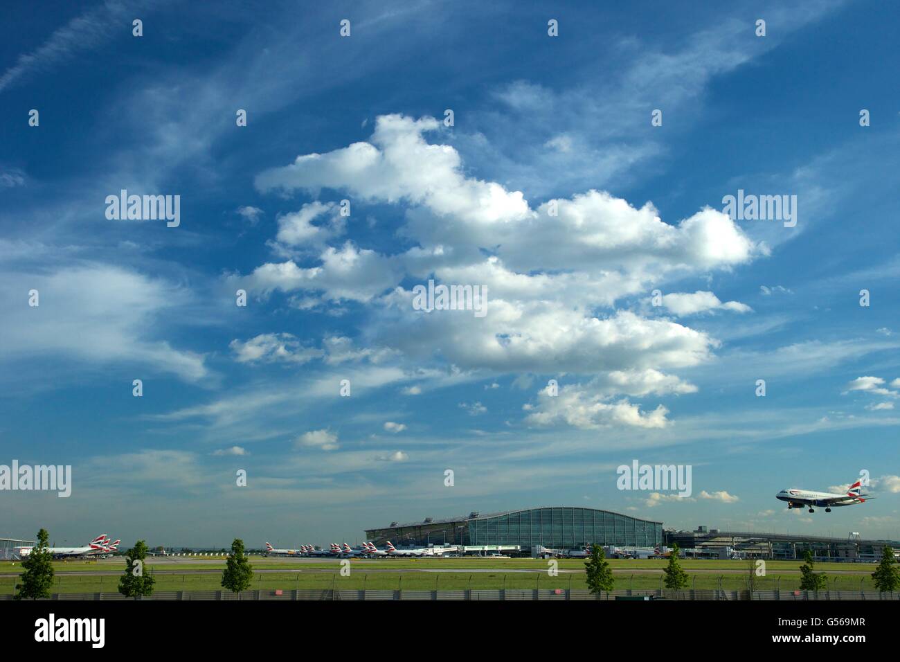 British AIrways flight landing at Heathrow Airport with Terminal 5 behind, London, England, UK, GB, Stock Photo