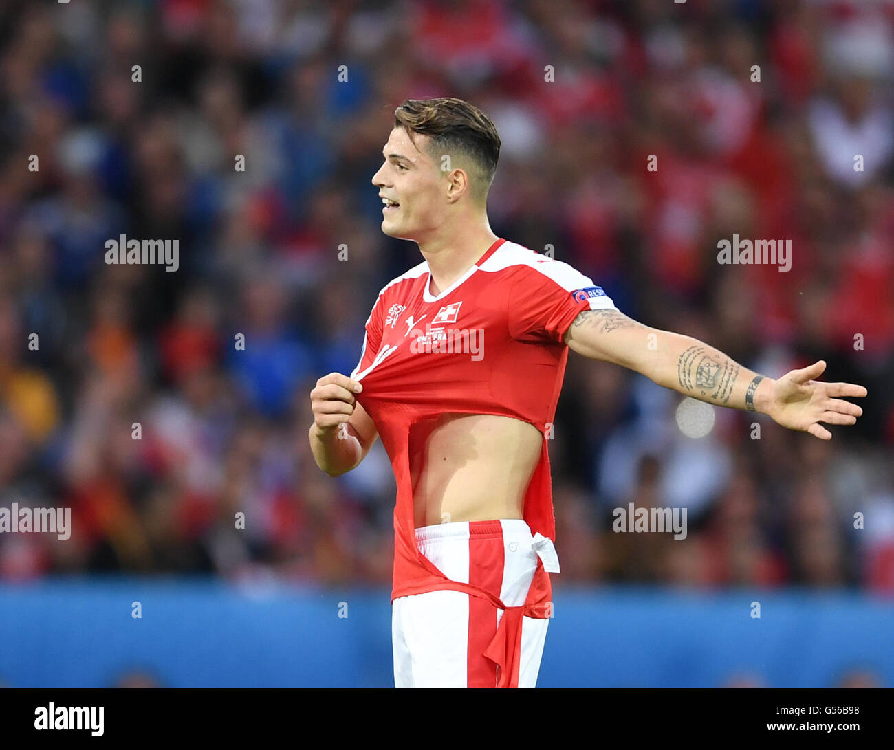 Lille, France. 19th June, 2016. Granit Xhaka of Switzerland shows his  jersey which was torned by Paul Pogba (not seen) of France during the  preliminary round match between Switzerland and France at