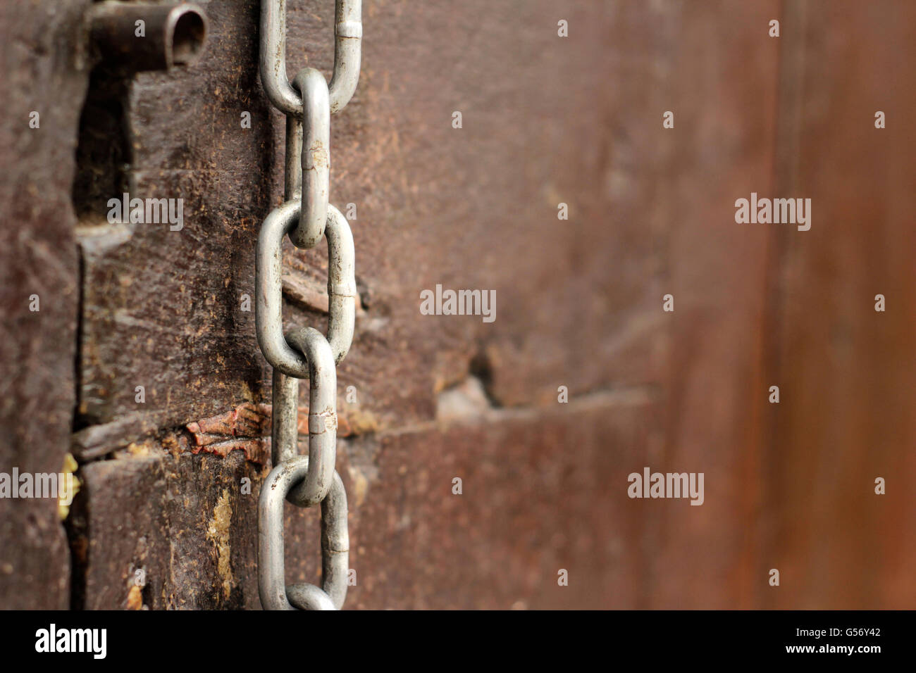 Photograph of a metal chain on wood door Stock Photo