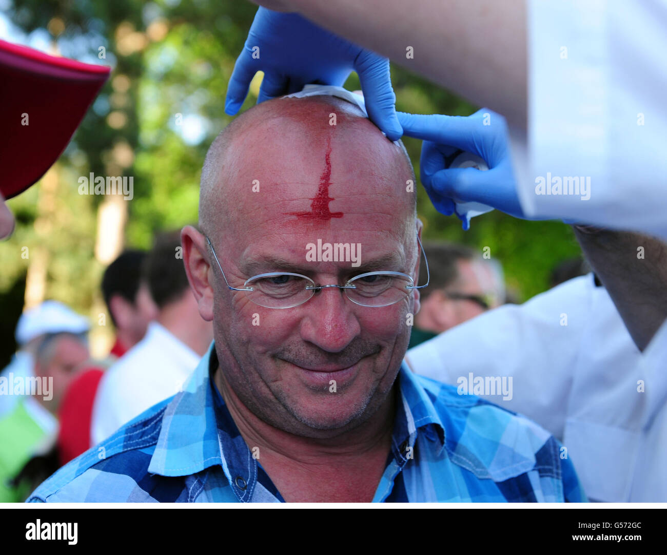 Spectator John Clarke receives medical attention after getting hit on the head by a ball from Rory McIlroy during the Second Round at Wentworth Stock Photo