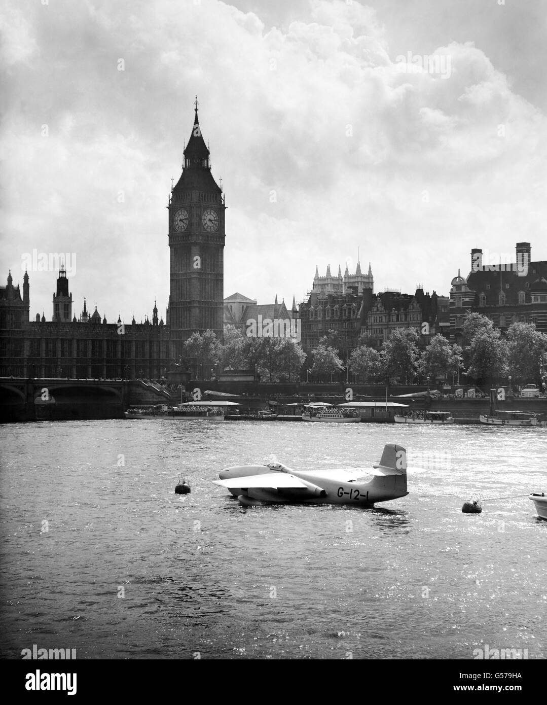 Looking tiny on the broad expanse of the Thames beneath the towering Big Big, the sleek Saunders-Roe A1 - the world's only jet flying boat fighter - is moored off the South Bank Exhibition, London. Stock Photo