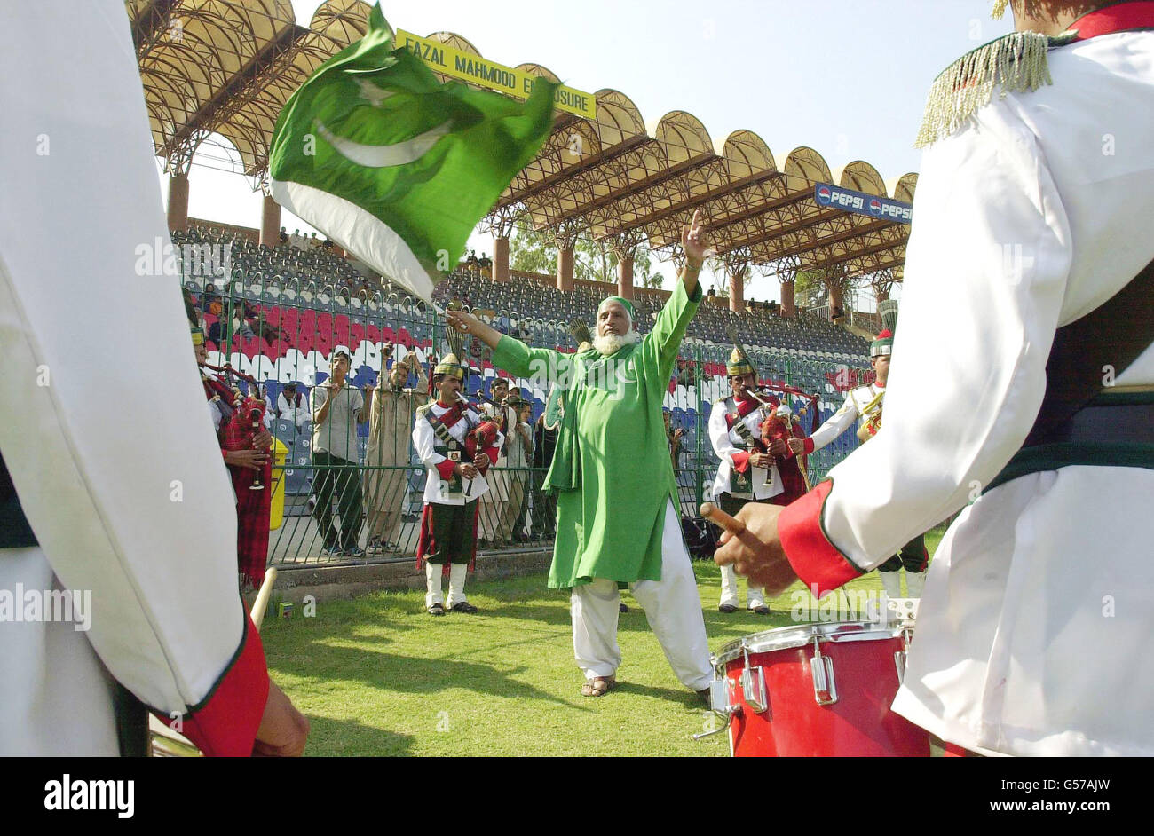 Pakistani cricket fan Abdul Jalil, who is known as 'Uncle Cricket', enjoys the music of the Pakistan Ground Army Pipe Band (Azad Kashmir Regiment) during the final day of the first test match between England and Pakistan at Lahore. Stock Photo