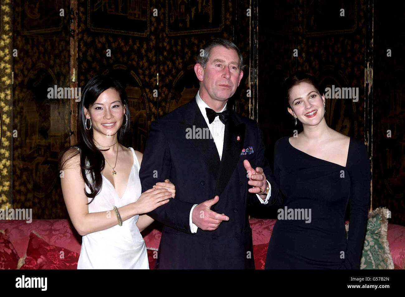 The Prince of Wales, flanked by two Charlie's Angels, hosted a dinner for actresses Lucy Liu (left) and Drew Barrymore at St James' Palace in aid of the Prince's Trust. Stock Photo