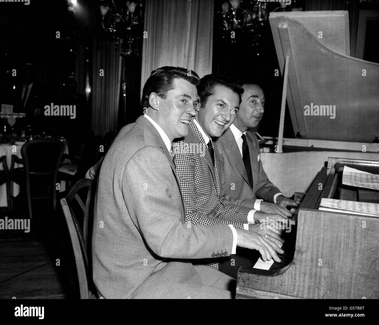 RUSS CONWAY 1960: Pictured at the keys in London's Dorchester Hotel are (l-r) British pianist Russ Conway, American pianist Liberace and British bandleader Stanley Black. They were all attending the Variety Club's 'Golden Disc' Luncheon. (Conway d.16/11/2000 in Eastbourne). Stock Photo