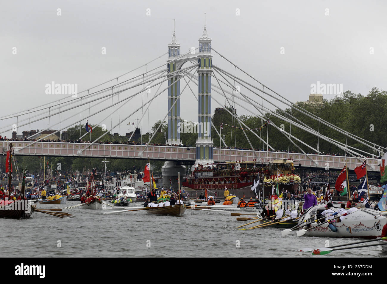 Boats pass the Royal Barge at Putney Bridge as they head towards Tower Bridge along the River Thames, during the Diamond Jubilee River Pageant, in London. Stock Photo