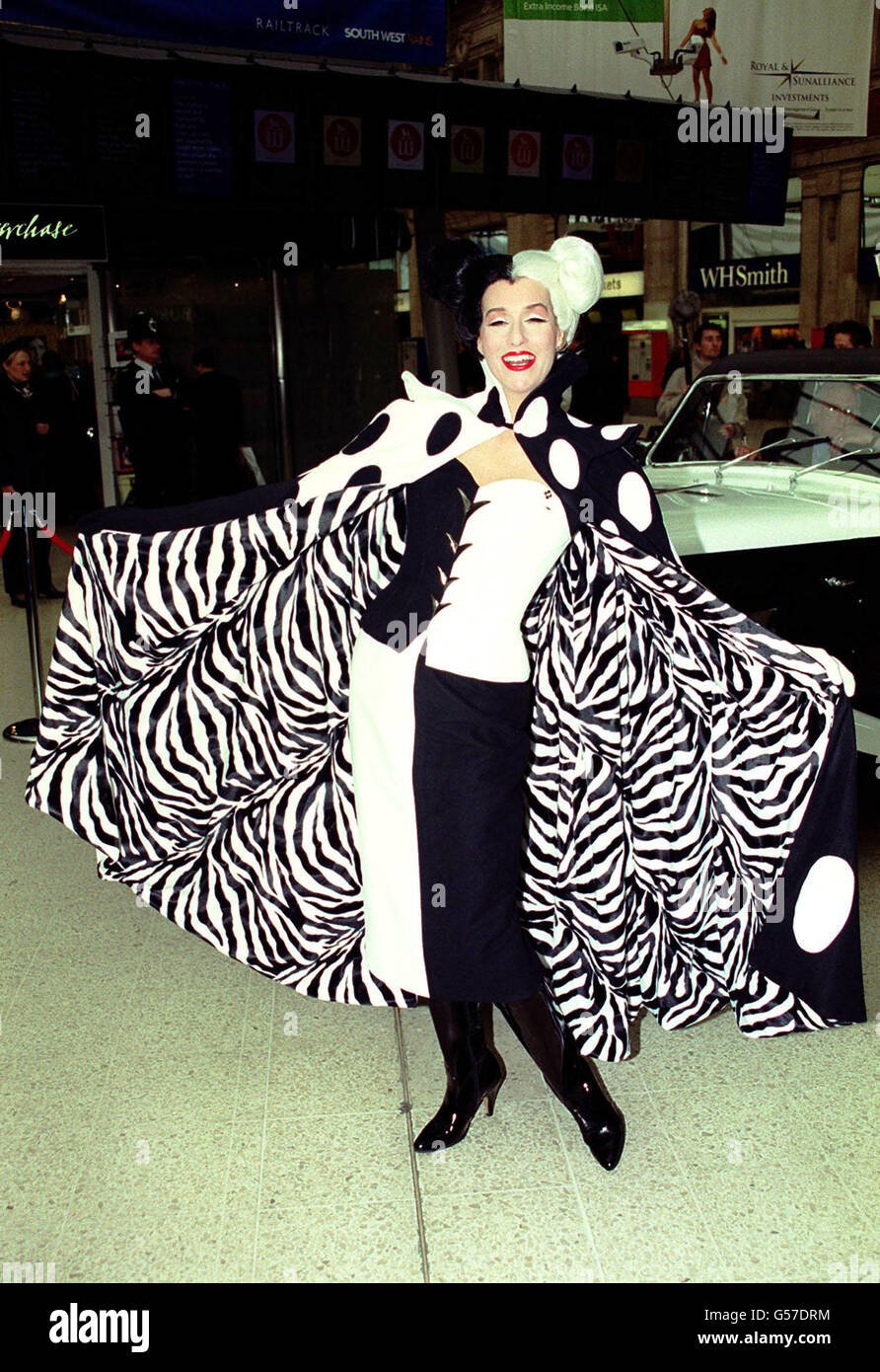 Cruella DeVil at Waterloo Station in London to launch Disney's 102 Dalmations Eurostar train. All 18 coaches of the train are covered with images of Dalmation puppies and the train will be in service on the Brussels, Paris and Disneyland Paris routes. Stock Photo