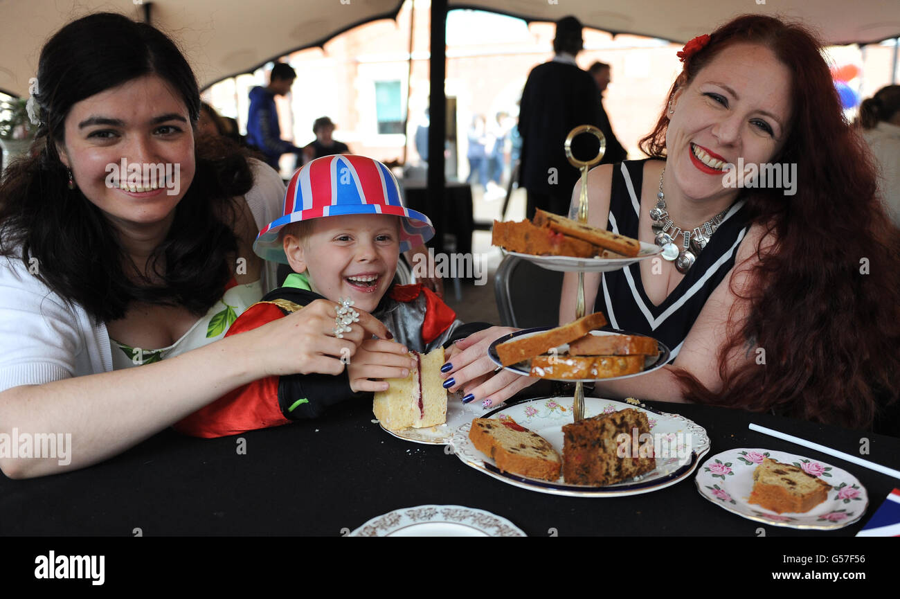 (L-R) Charis Croft, Daniel Barker and Rowan Gibson fight over a slice of cake in the Pavilion Marquee at The Kia Oval. Stock Photo