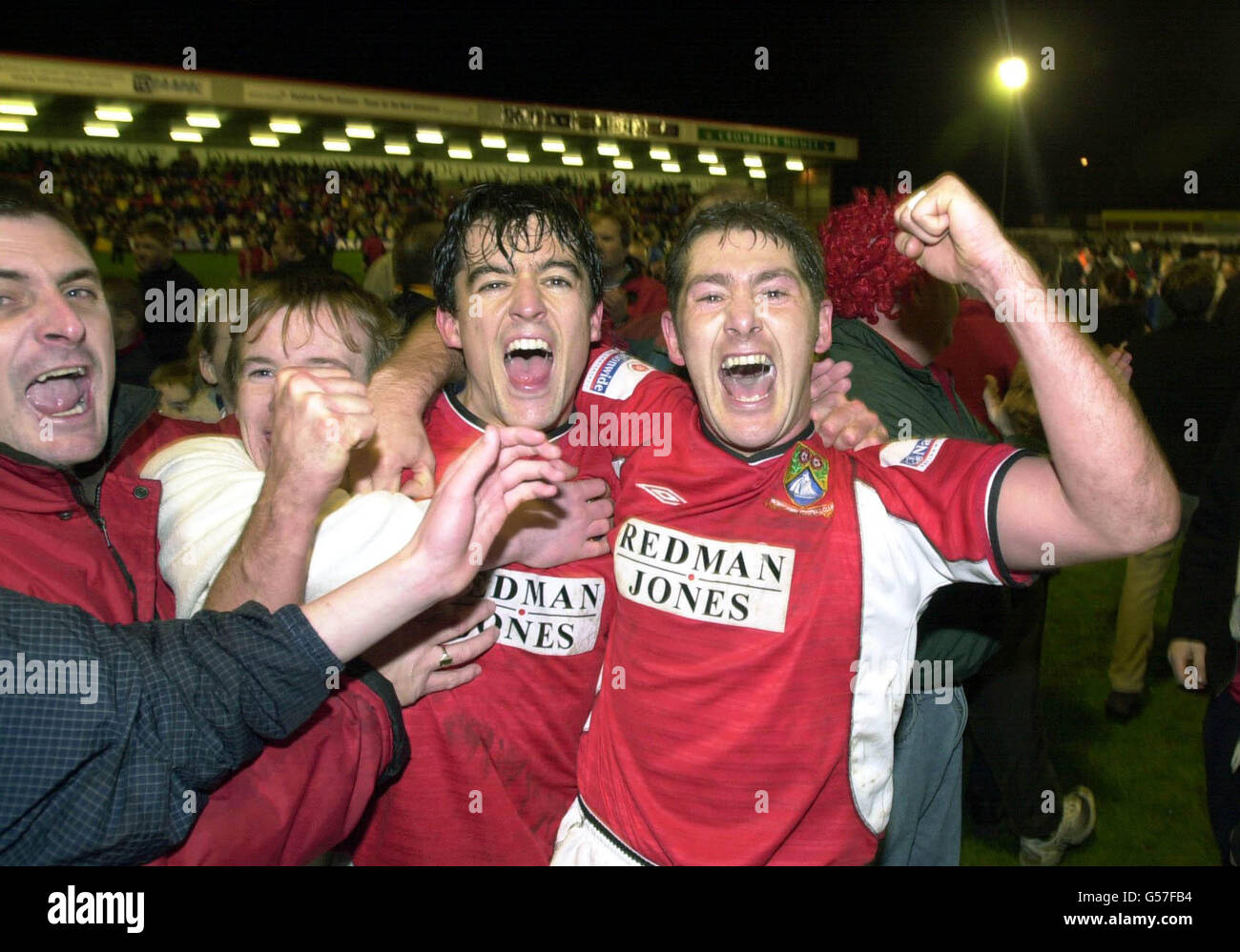 Morecambe players Mark Quayle and John Norman are mobbed by fans after