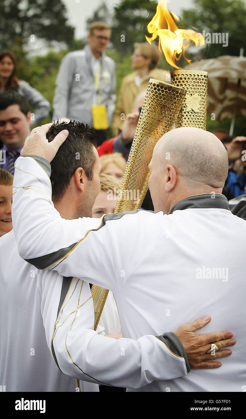 Olympic silver medal winning boxer Michael Carruth (right) receives the flame from Olympic gold medal winner Wayne McCullough (left) during the ceremony to hand over the Olympic Torch at the border crossing between the Republic of Ireland and Northern Ireland on Day 19 of the Olympic torch relay. Stock Photo