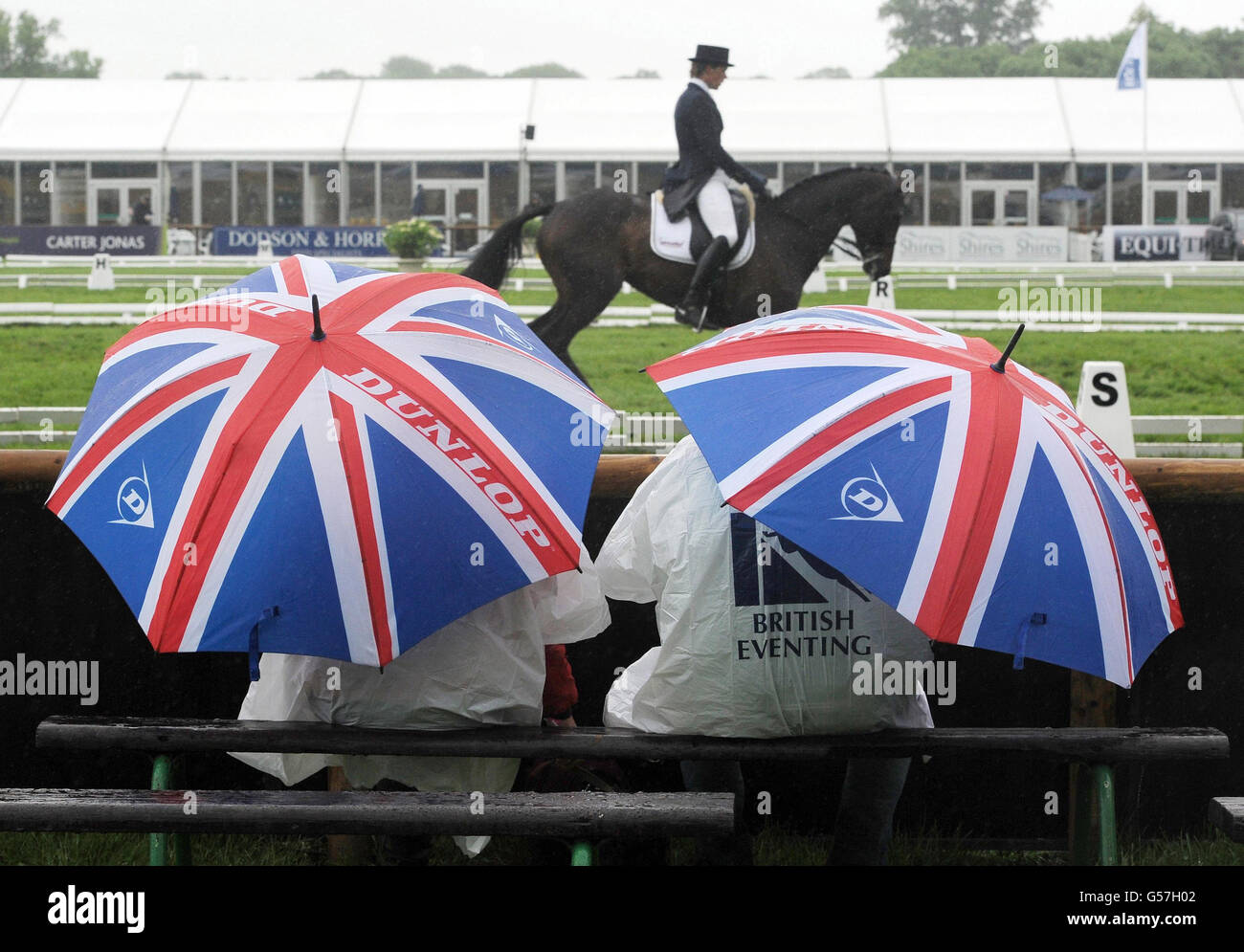 Spectators brave the rain to watch the Dressage event during the Bramham International Horse Trials at Bramham Park, Wetherby. Stock Photo