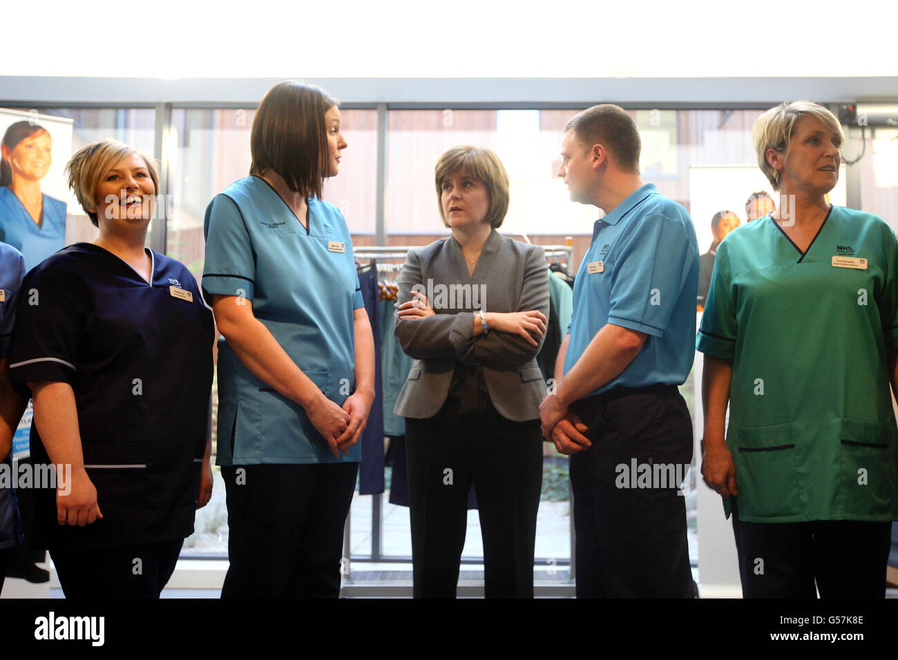 Health Secretary Nicola Sturgeon during a visit to the New Stobhill Hospital in Glasgow to launch of the new NHS Scotland national uniforms talks to Speech and Language Therapist Natalie Turner (second left) Senior Charge Nurse Pamela Burns (l) Stock Photo