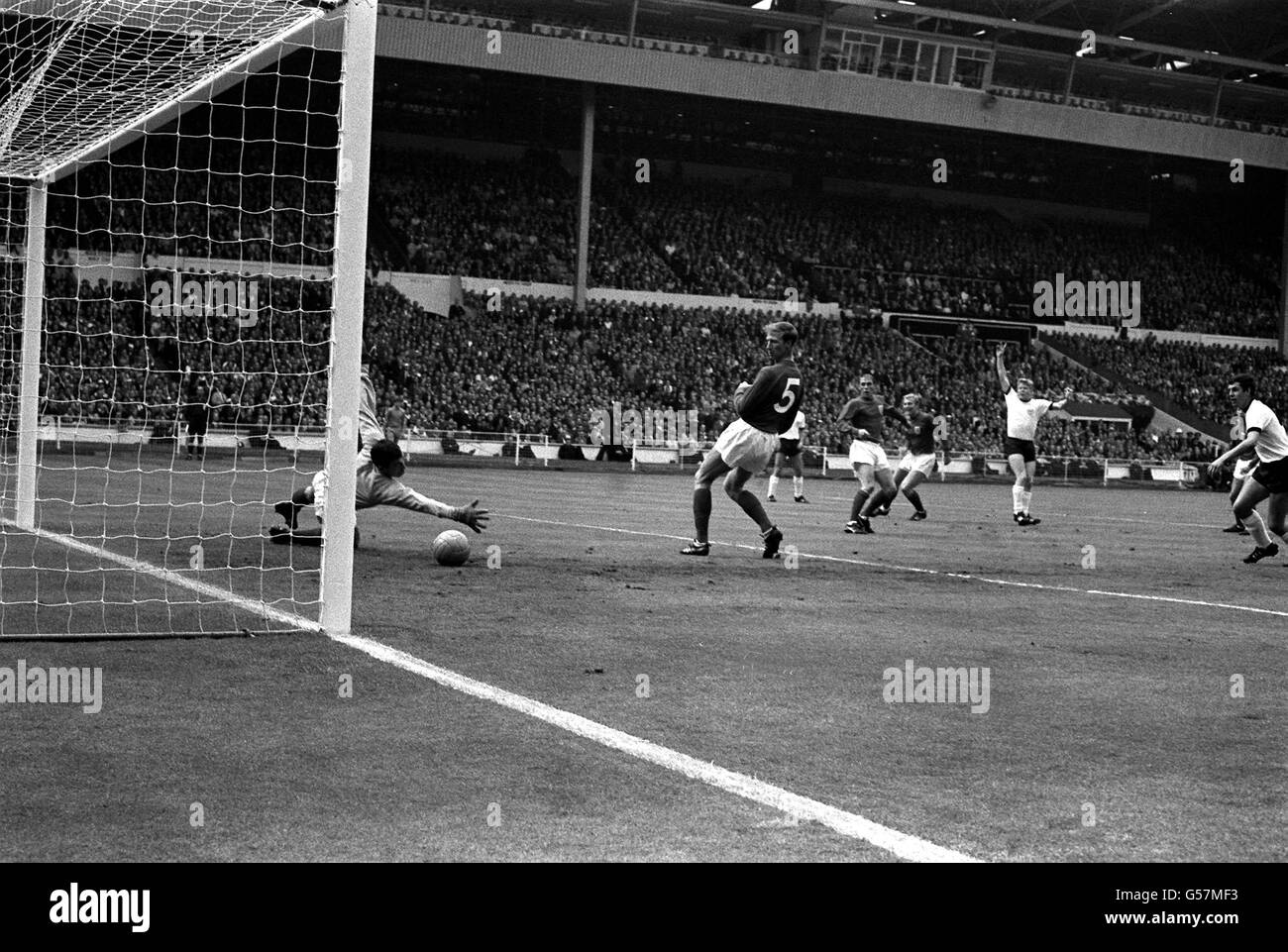 WORLD CUP 1966: The ball eludes the clutching hands of England goalkeeper Gordon Banks and goes into the net to give West Germany a 1-0 lead after 13 minutes in the World Cup Final at Wembley Stadium. The scorer was Helmut Haller. * England players in the picture are (l-r) Ray Wilson, Jackie Charlton and Bobby Moore. 7/3/01: Legendary goalkeeper Banks is to auction off his 1966 World Cup winning medal. The England star played in the side that beat the former West Germany 4-2 at Wembley to win football's greatest prize. Experts believe that the medal will fetch between 70,000 and 90,000 at the Stock Photo